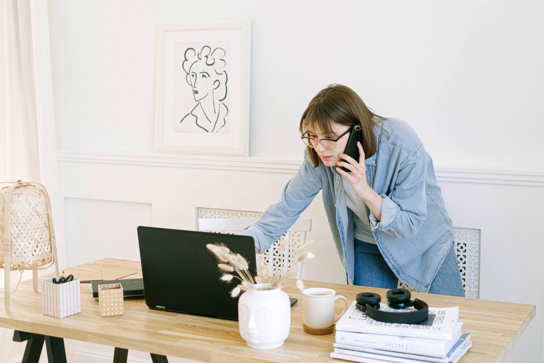 Woman working on phone and laptop